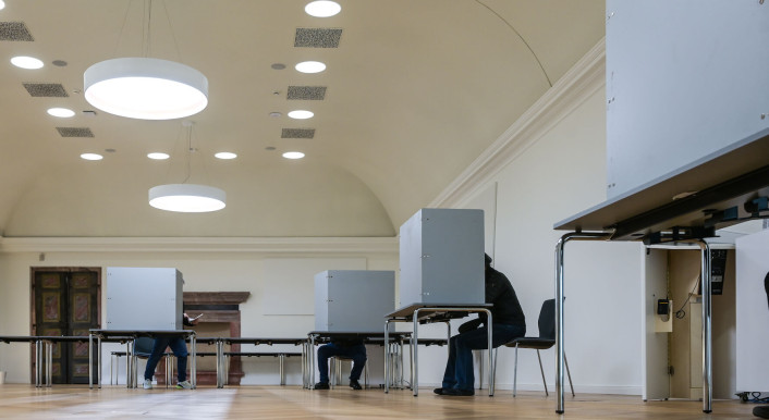 Menschen sitzen in Wahlkabinen im "Goldenen Saal", in dem sich ein Wahllokal der Stadt Sangerhausen befindet, um ihre Stimme abzugeben. Am Sonntag findet die vorgezogene Wahl zum 21. Deutschen Bundestag statt.