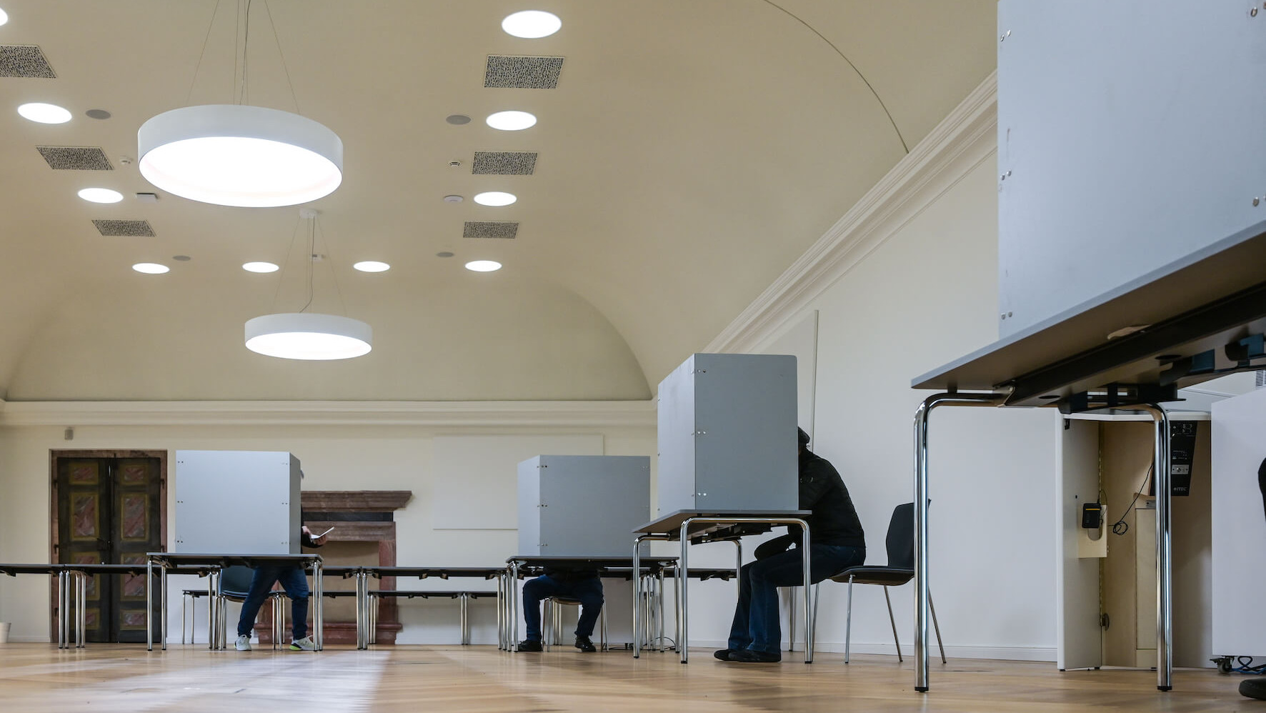 Menschen sitzen in Wahlkabinen im "Goldenen Saal", in dem sich ein Wahllokal der Stadt Sangerhausen befindet, um ihre Stimme abzugeben. Am Sonntag findet die vorgezogene Wahl zum 21. Deutschen Bundestag statt.