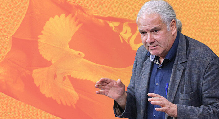 Der frühere Linken-Politiker und heutige BSW-Bundestagsabgeordnete Andrej Hunko hebt die Hände während einer Rede. Er steht vor blauem Hintergrund, unter anderem Friedens-Fahnen sind zu sehen. Collage: Ivo Mayr/CORRECTIV (Vorlage:picture alliance)