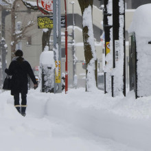 Ein Fußgänger in Japan läuft durch hohen Schnee