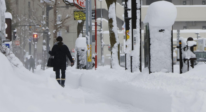 Ein Fußgänger in Japan läuft durch hohen Schnee