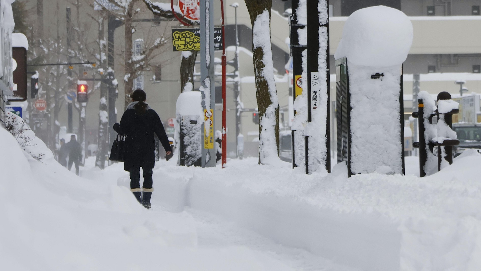 Ein Fußgänger in Japan läuft durch hohen Schnee