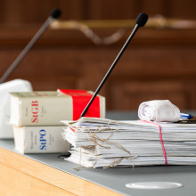 Unterlagen sowie die Strafprozessordnung (StPO) und Strafgesetzbuch (StGB) liegen auf einem Tisch im Gericht