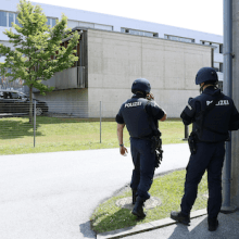 Zwei Polizeibeamte vor einem Gebäude.
