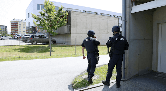 Zwei Polizeibeamte vor einem Gebäude.