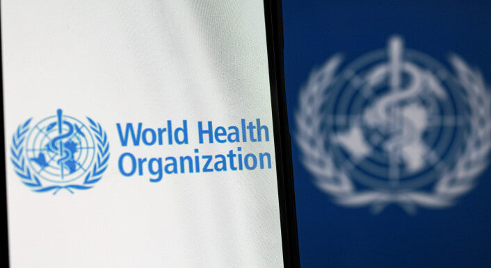 Auf einem Bildschirm ist das Logo der Weltgesundheitsorganisation zu sehen