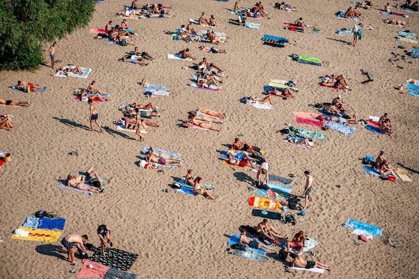 Menschen sonnen sich am Strand
