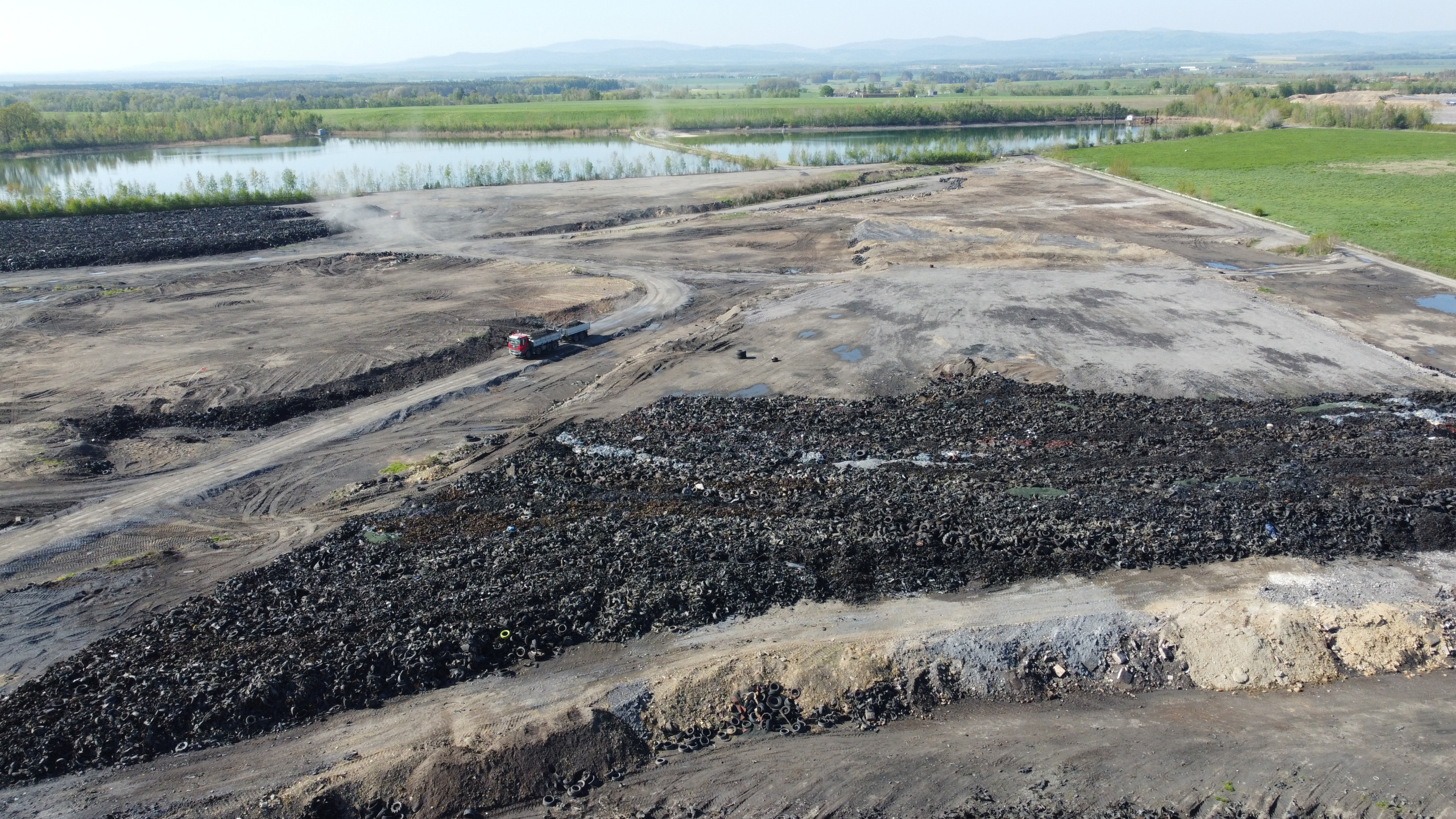 MydlovaryMichaelBillig010 Eine Landschaft in grau und schwarz: Mit gebrauchten Reifen, Aschen aus Verbrennungsanlagen und Schlacken aus Stahlwerken werden die Uranschlammteiche abgedeckt. So soll eine weitere Kontamination der umliegenden Äcker und Dörfer verhindert werden. Credits: Michael Billig