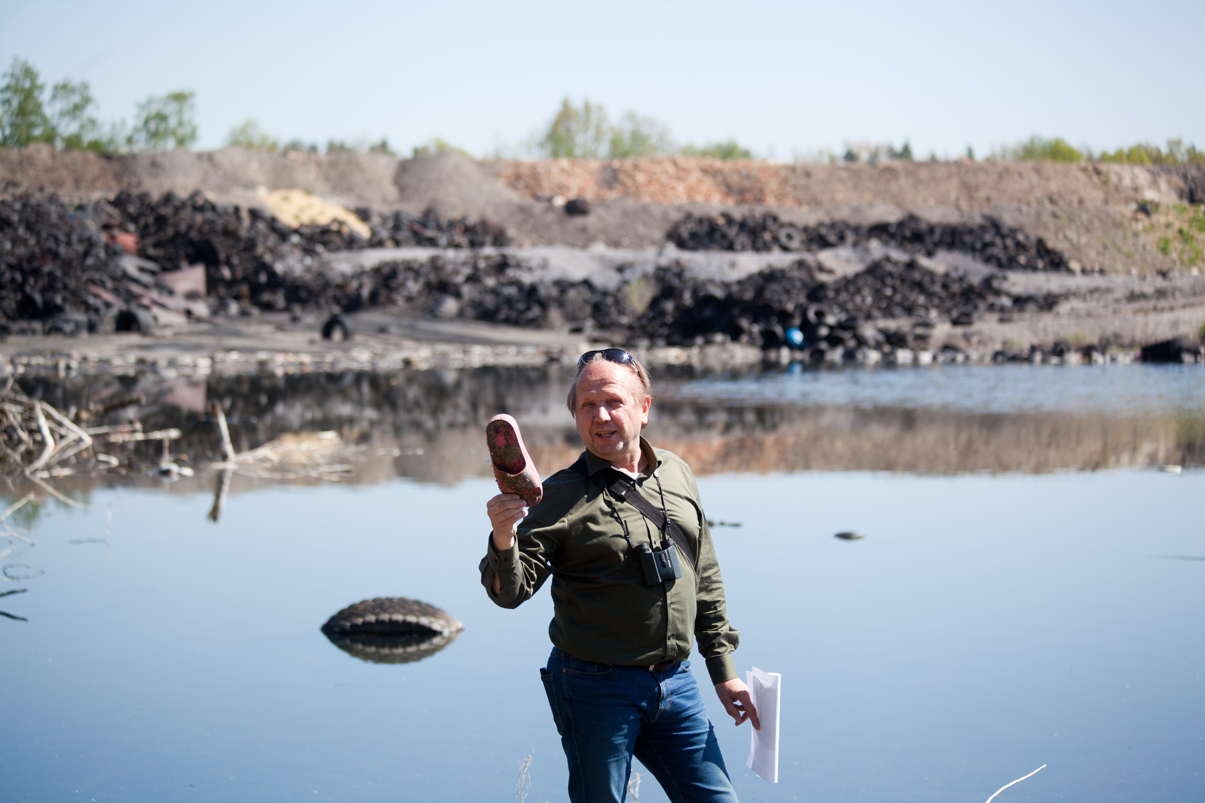 Švehla-mydlovary-waste Chemist Jaroslav Švehla at one of the uranium sludge ponds near Mydlovary, holding one of the many pieces of rubber footwear dumped here.