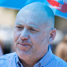 Joachim Frank steht bei einer Kundgebung unter einem Pavillon in AfD-Farben