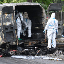 Die Spurensicherung untersucht einen ausgebrannten Transporter nach einem Brand in einem Münchner Einfamilienhaus im Münchner Stadtteil Lerchenau.
