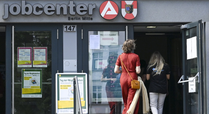 Zwei Personen laufen in ein Jobcenter