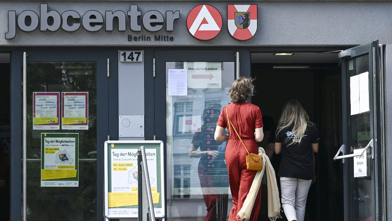 Zwei Personen laufen in ein Jobcenter