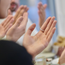 Betende Hände an einem Tisch mit Essen