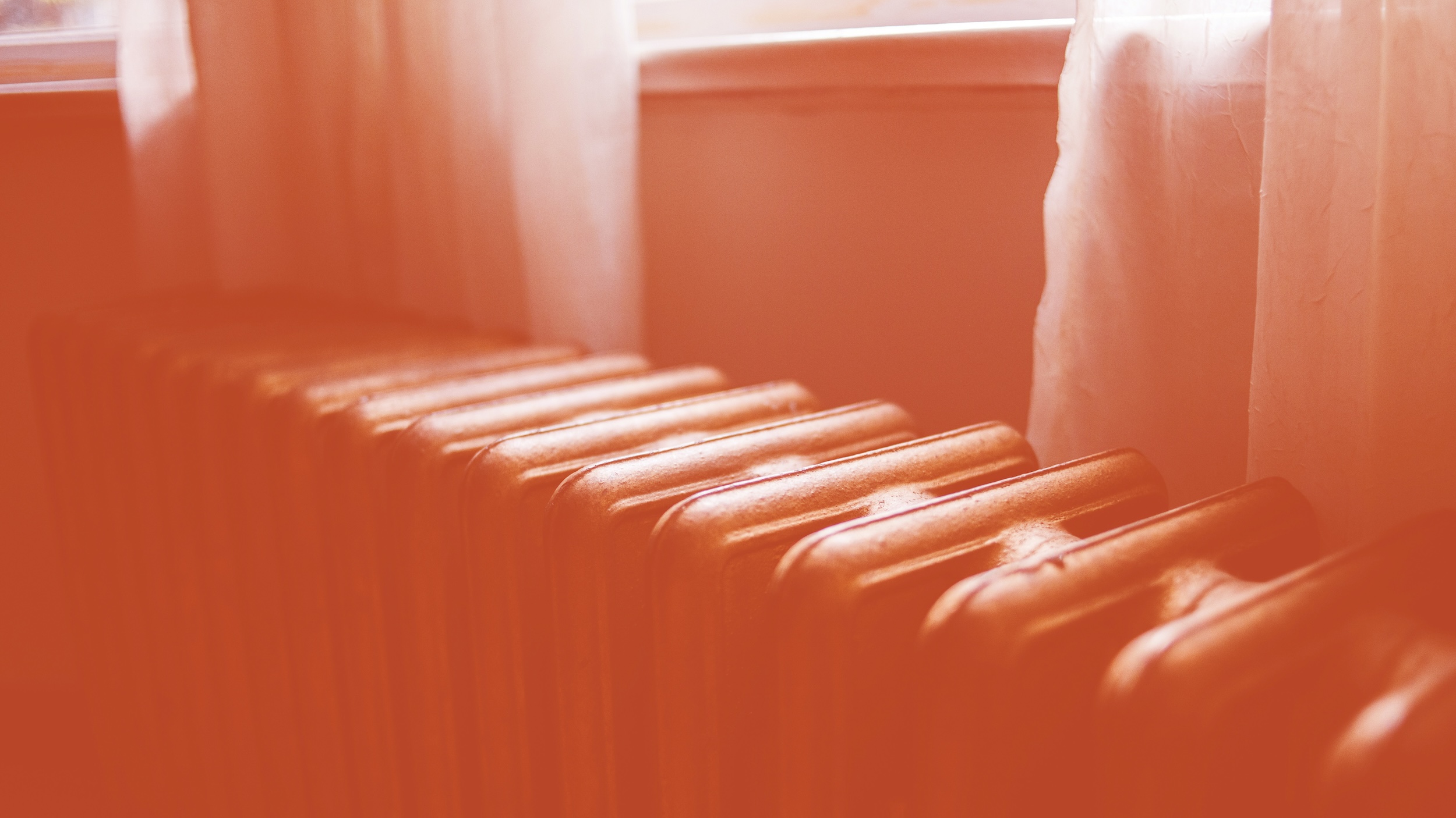 Auf dem Foto ist der Ausschnitt einer Heizung zu sehen. Darüber ein Stück einer Fensterbank