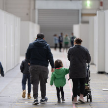 Eine Flüchtlingsfamilie geht durch die zu einer Massenunterkunft umfunktionierten Messehalle in Frankfurt.