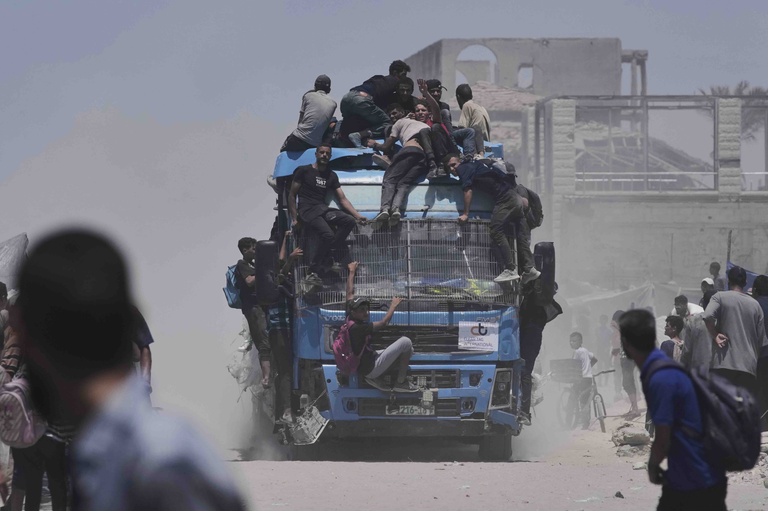 Palästinenser halten sich an einem Lastwagen mit Hilfsgütern fest, der am 22. Juli 2025 aus dem nördlichen Gazastreifen nach Gaza-Stadt zurückkehrt (Foto: Jehad Alshrafi / AP Photo / Picture Alliance)