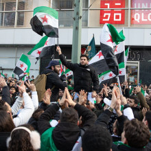 feiernde Menschen mit syrischen Flaggen in Berlin am Alexanderplatz