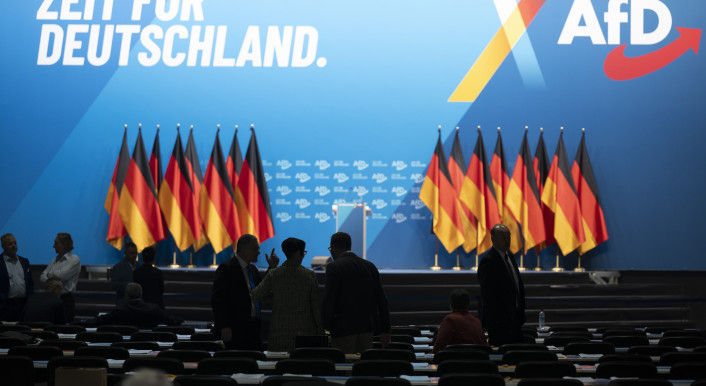 Deutschlandfahnen, leere Sitzreihen, AfD-Slogan "Zeit für Deutschland" sind zu sehen.