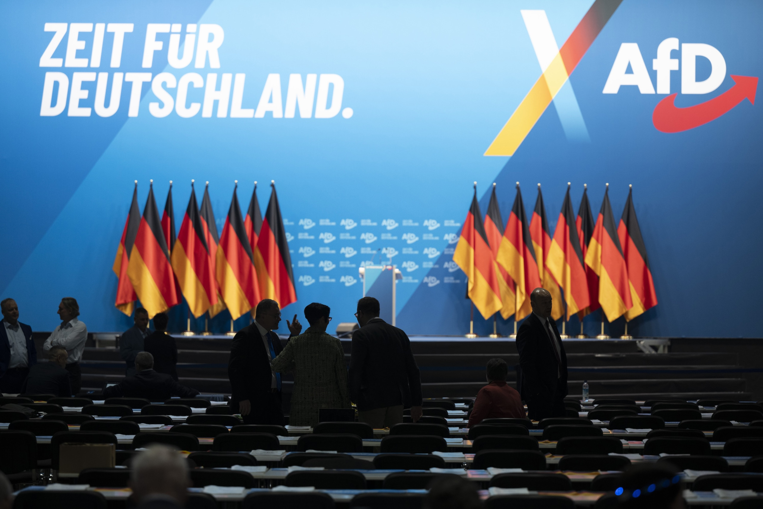 Deutschlandfahnen, leere Sitzreihen, AfD-Slogan "Zeit für Deutschland" sind zu sehen.