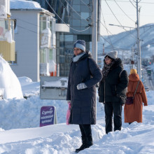 Menschen stehen an einer Straße auf Schneebergen in Kamtschatka