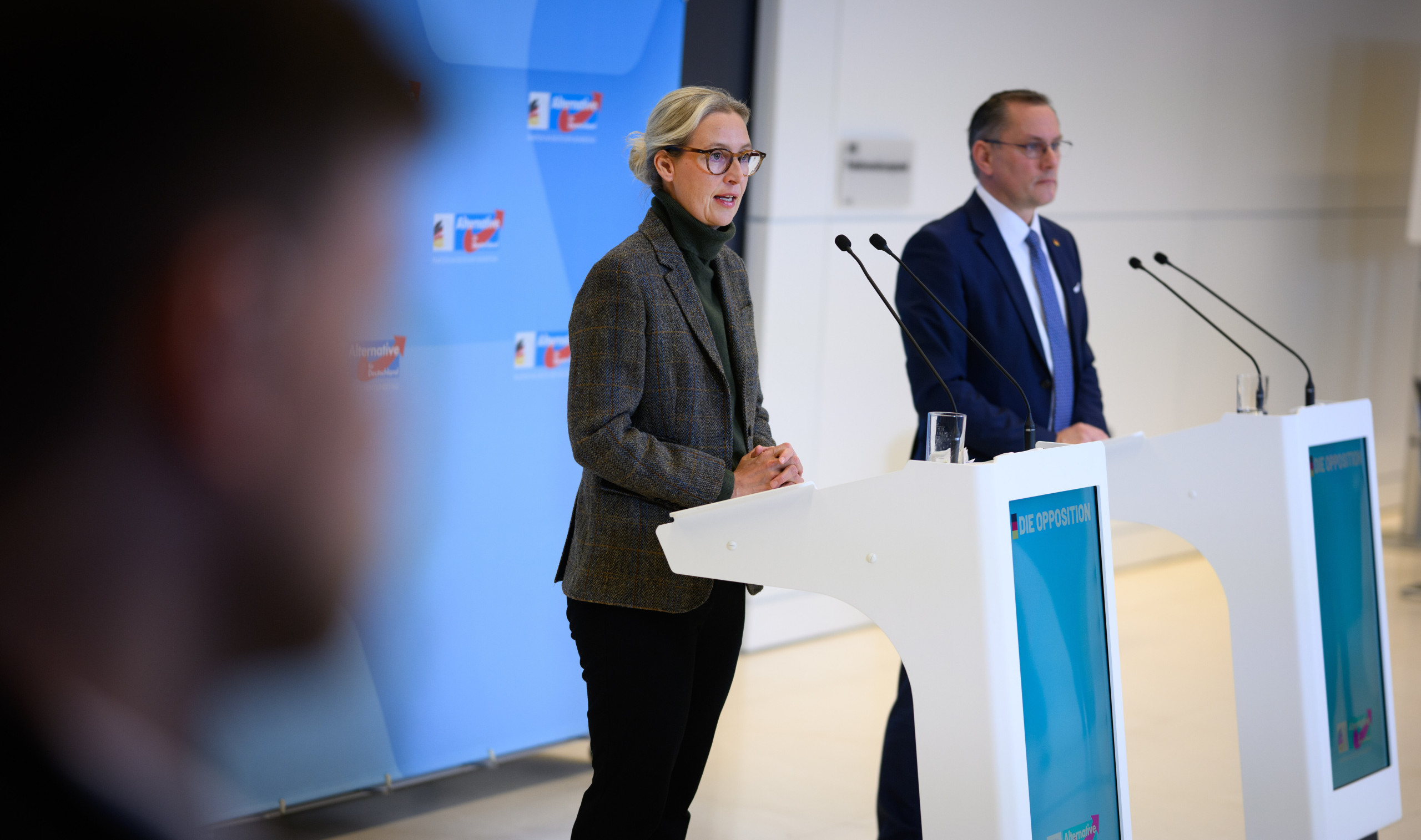 AfD-Co-Chefs Alice Weidel und Tino Chrupalla stehen an Rednerpulten.