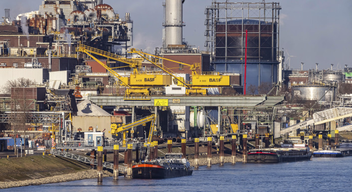 Werksgelände von BASF mit Chemieanlagen und Schornsteinen. Badische Anilin und Soda Fabriken. Chemiefabrik. Hafenkräne bei der Entladung eines Frachtschiffs. Ludwigshafen am Rhein, Rheinland-Pfalz, Deutschland