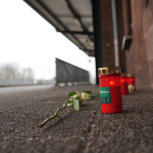 Eine Blume und Kerzen liegen am Bahnsteig