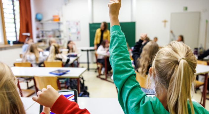 Kinder melden sich im Unterricht