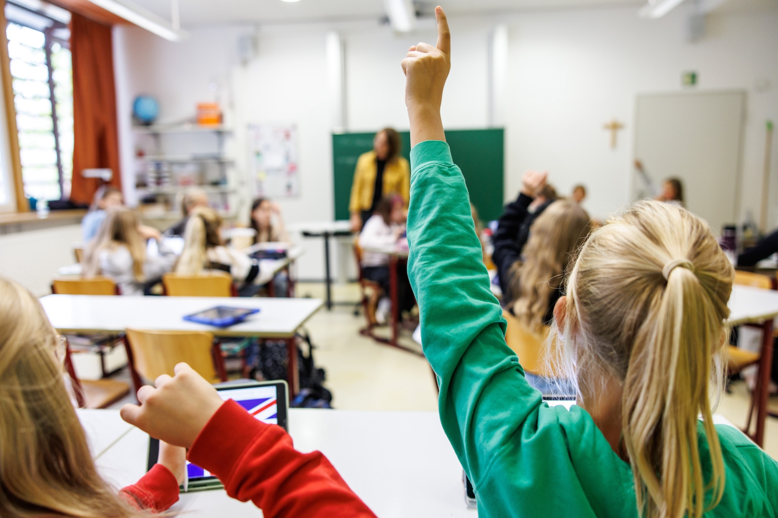 Kinder melden sich im Unterricht