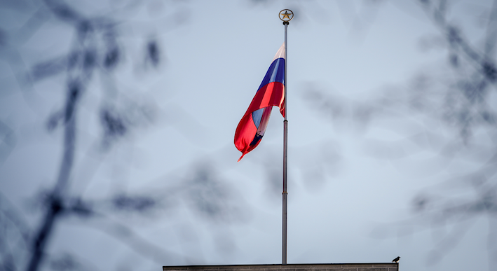 Bild einer russischen Flagge, die an einem Fahnenmast hängt.