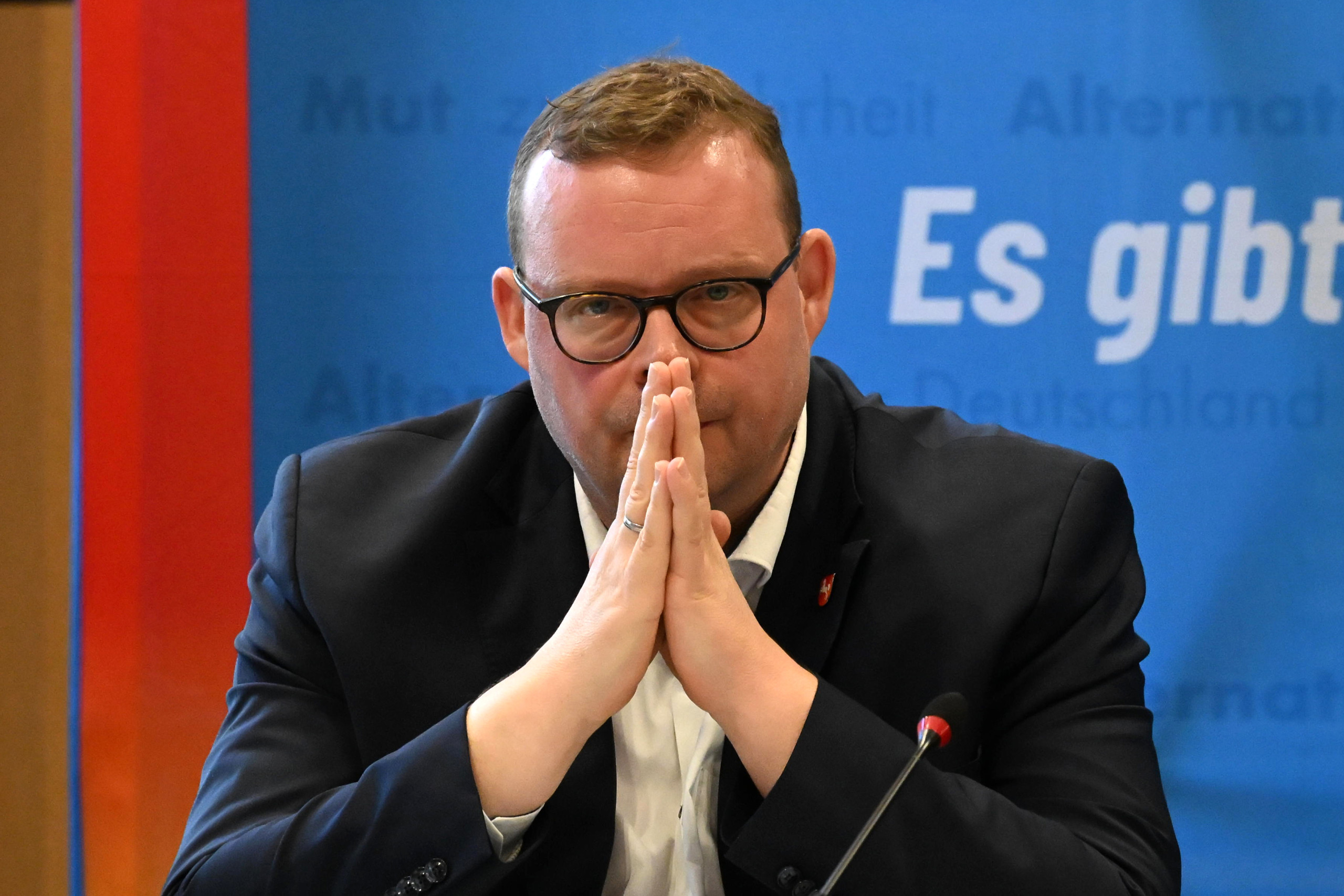 Das Foto zeigt Ansgar Schledde, AfD-Landeschef in Niedersachsen. Er sieht bedrückt aus und hat die Hände vor dem Gesicht zusammengefaltet, die Handflächen zeigen zueinander. Die Staatsanwwaltschaft Hannover ermittelt gegen Schledde und zehn weitere Personen der AfD Niedersachsen.