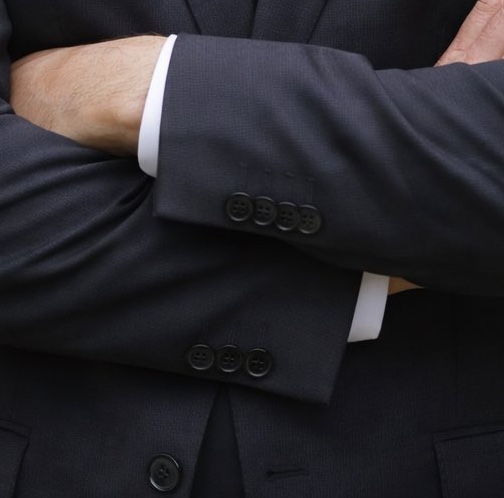 An den Ärmeln des Jacketts sind Fehler sichtbar: auf einer Seite drei, auf der anderen vier Knöpfe 