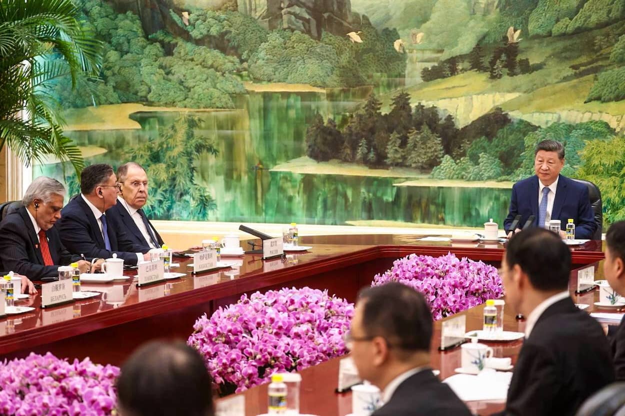 Treffen der Außenminister, darunter Sergej Lawrow (links). in Peking - alle sitzen in einem Saal am Konferenztisch vor Xi Jinping