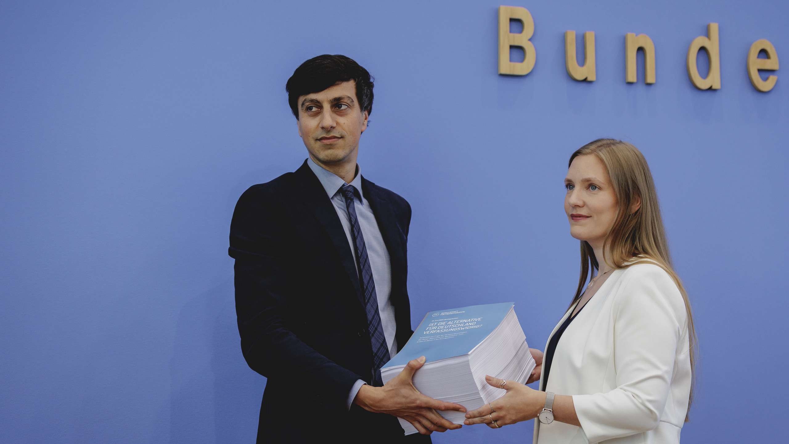 Zwei Personen halten ein sehr dickes Gutachten in Papierform zur Verfassungswidrigkeit der AfD. Das Gutachten der Gesellschaft für Freiheitsrechte wurde in der Bundespressekonferenz vorgestellt.