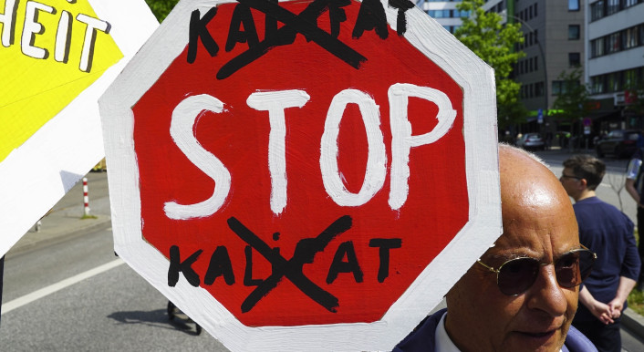 Ein Schild auf einer Demo, auf dem „Stop Kalifat“ steht