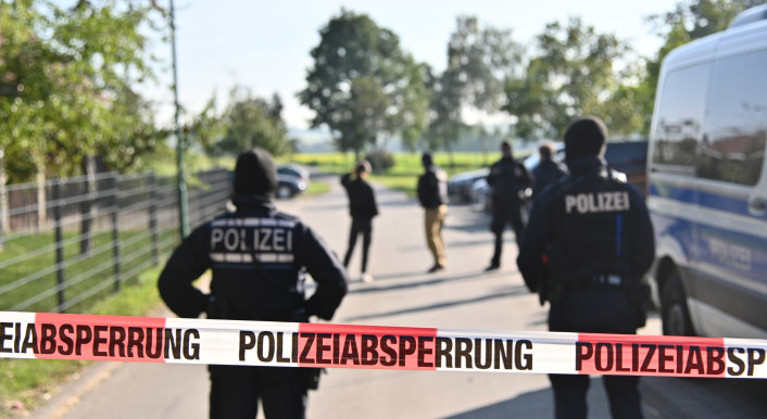 Einsatzkräfte der Polizei stehen hinter einer Polizeiabsperrung. Bundesinnenministerin Faeser (SPD) hat eine weitere rechtsextremistische Vereinigung verboten. Einsatzkräfte der Polizei durchsuchten am Mittwochmorgen 26 Wohnungen von 39 Mitgliedern sowie Räume des Vereins «Die Artgemeinschaft - Germanische Glaubens-Gemeinschaft wesensgemäßer Lebensgestaltung» in zwölf Bundesländern, wie das Innenministerium in Berlin mitteilte. (zu dpa "Razzien gegen völkische Siedler - Faeser verbietet «Artgemeinschaft»")