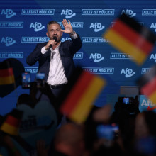 Der AfD-Spitzenkandidat für die Landtagswahl Ulrich Siegmund steht auf einer Bühne. Er trägt Anzug. Im Vordergrund und zur Kamera mit dem Rücken zugewandt ist eine Menschenmenge, die ihm zujubelt.