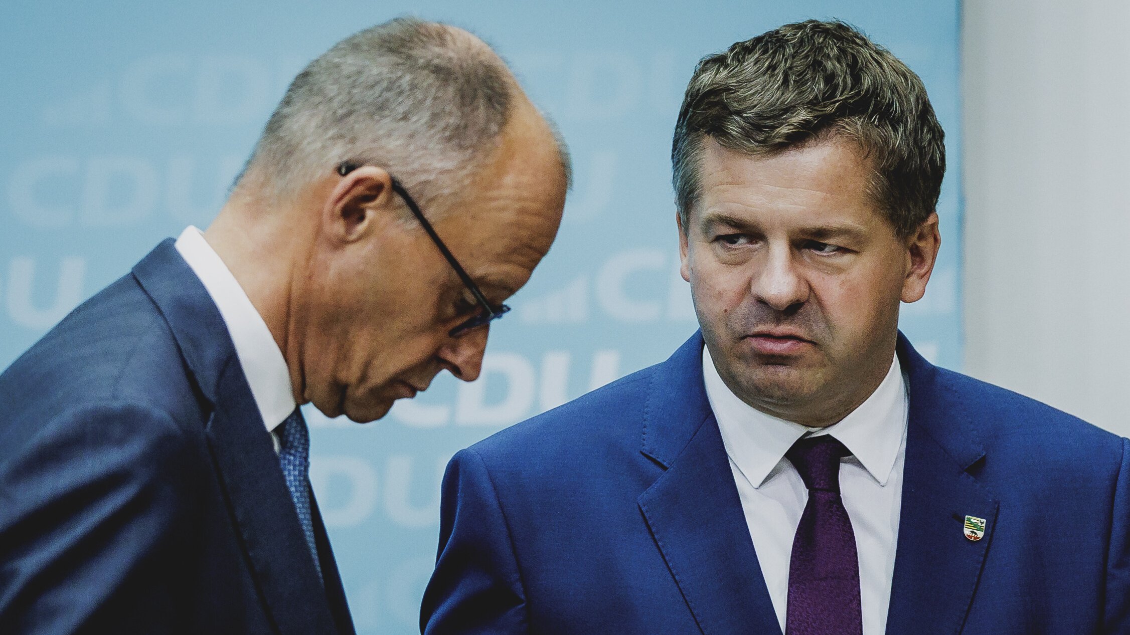Kanzler Friedrich Merz und Sachen-Anhalts Ministerpräsident Sven Schulze stehen nach der Wahl-Schlappe in Sachsen-Anhalt auf der Bühne. Merz lässt den Kopf sichtbar hängen, Schulze guckt ernst.