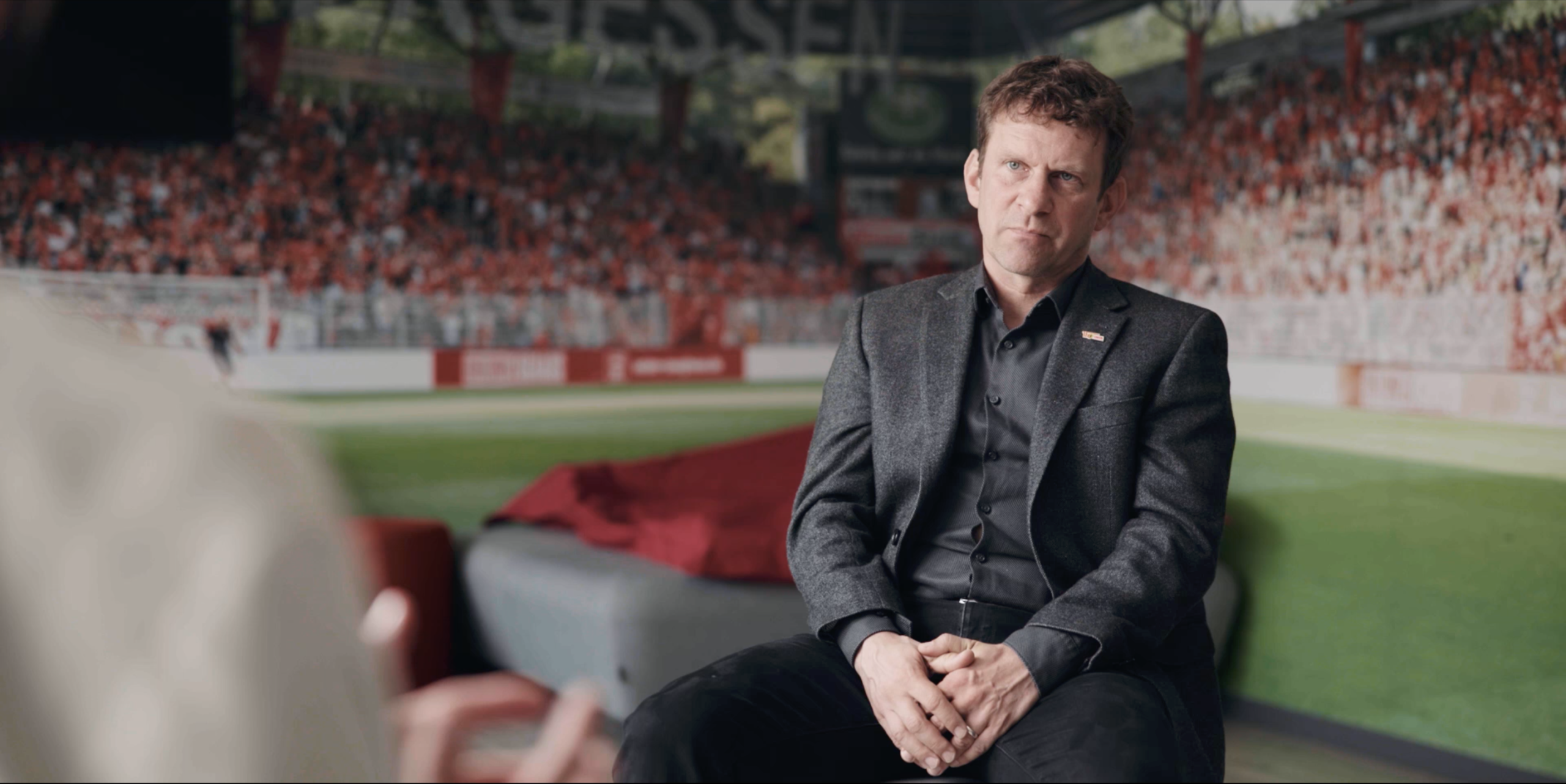 Geschäftsführer für Nachwuchs Lutz Munack von Union Berlin sitzt auf einem Stuhl in einem Interview-