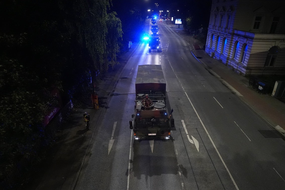 Ein Militär-LKW fährt eine Straße entlang.