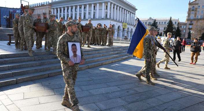 Bei einer Trauerfeier in Kiew trägt ein ukrainischer Soldat das Porträt eines Gefallenen.