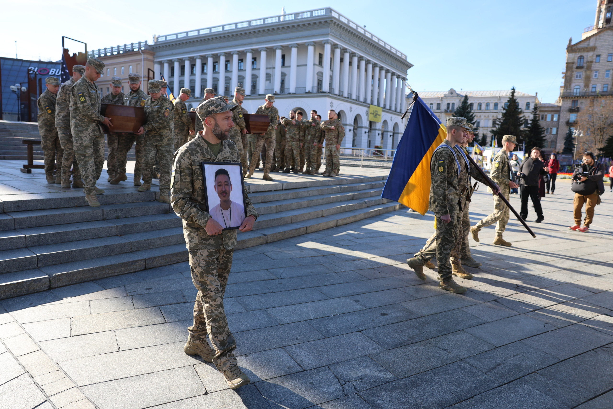 Bei einer Trauerfeier in Kiew trägt ein ukrainischer Soldat das Porträt eines Gefallenen.
