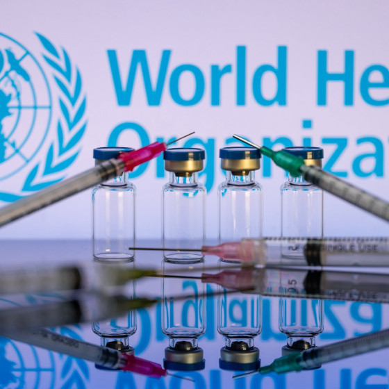 Impfstoff Ampullen vor dem Logo der WHO